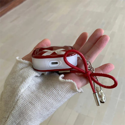 Cute silicone AirPods case with bow charm on pastel flat lay