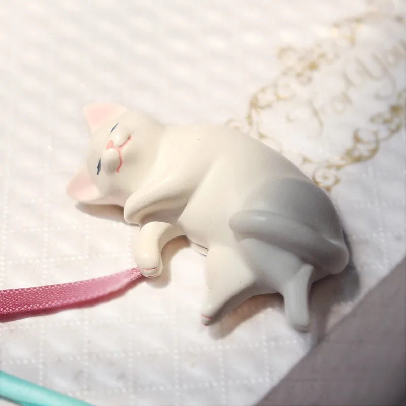 Individual kawaii cat miniature figure showing curled sleeping pose in resin
