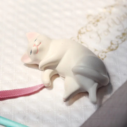 Individual kawaii cat miniature figure showing curled sleeping pose in resin