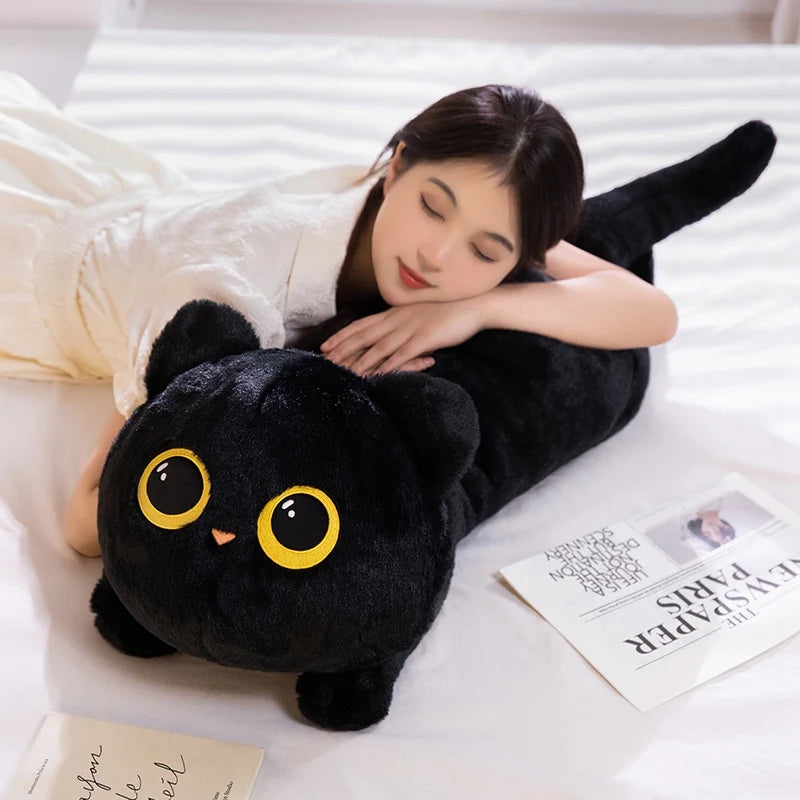 Grey kawaii cat plush cushion 70cm propped against bed headboard