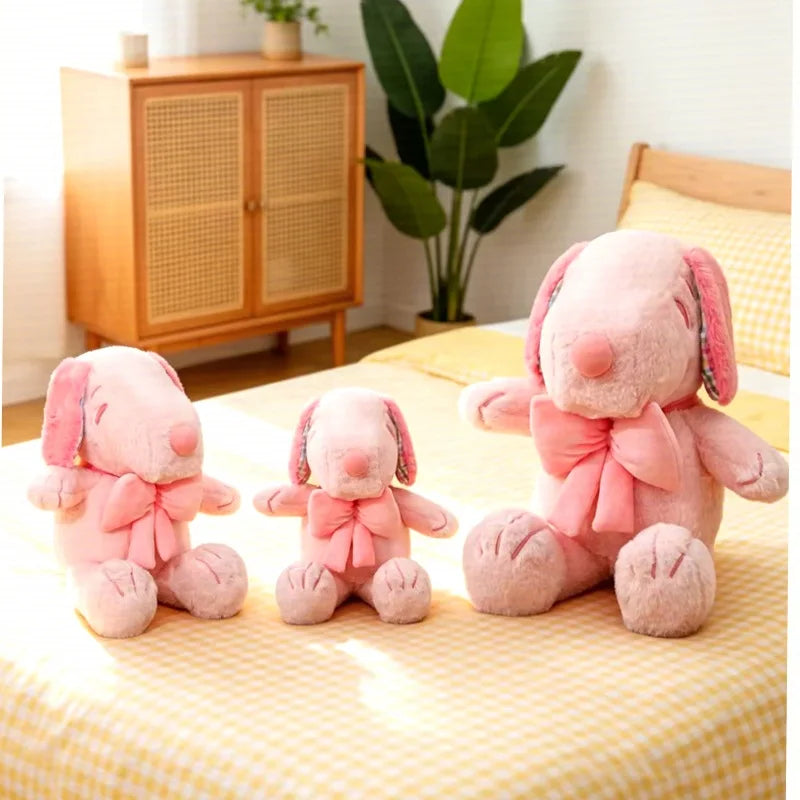 Kawaii pink Snoopy plushie in short velvet sitting pose with bow, front view