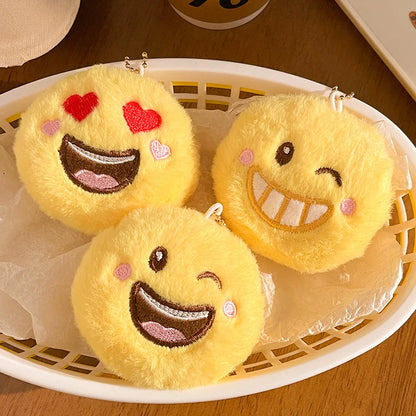 Three kawaii smile emoji plush keychain pendants in colorways A, B, and C displayed side by side