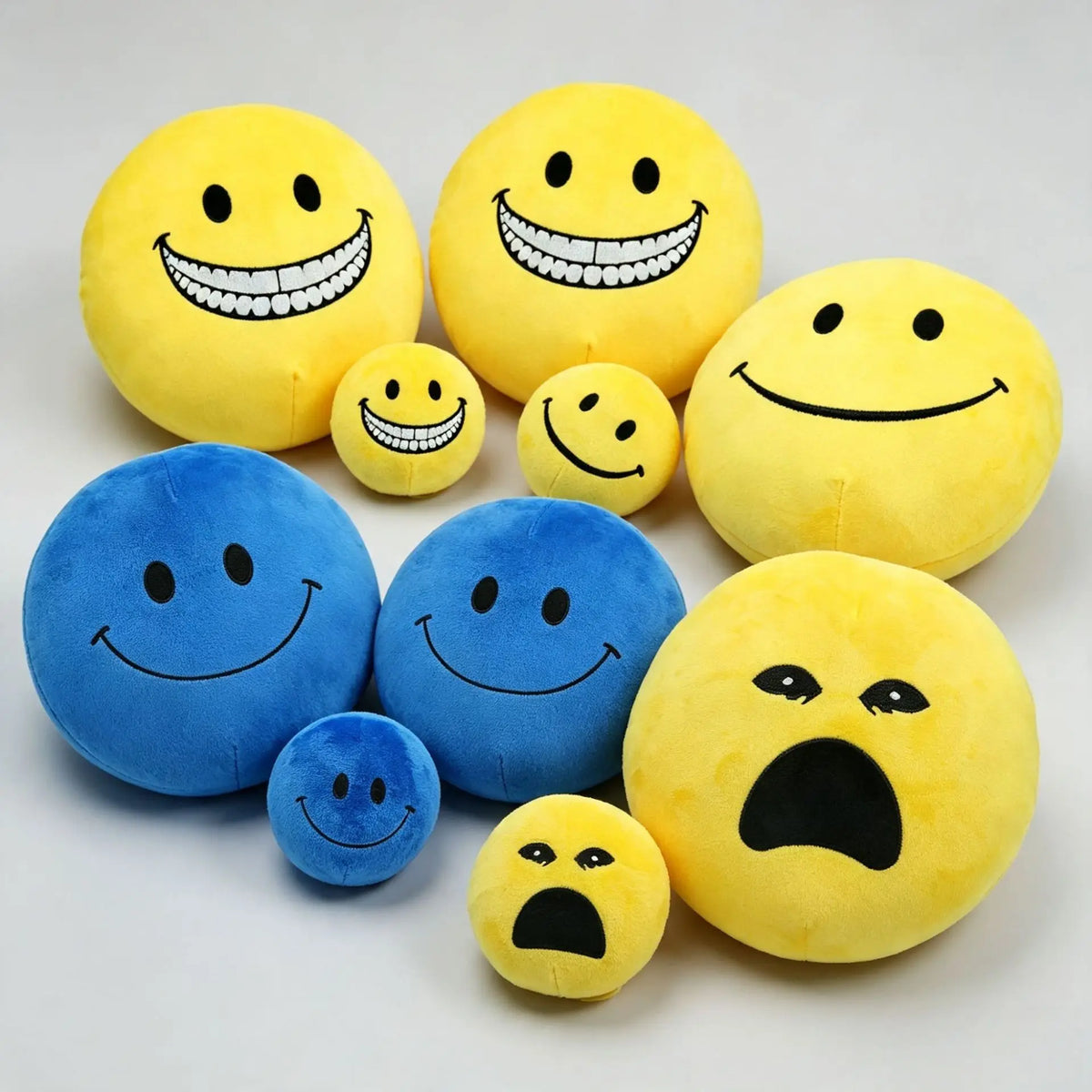 Kawaii smiley face plush ball in warm yellow, front view showing embroidered smile